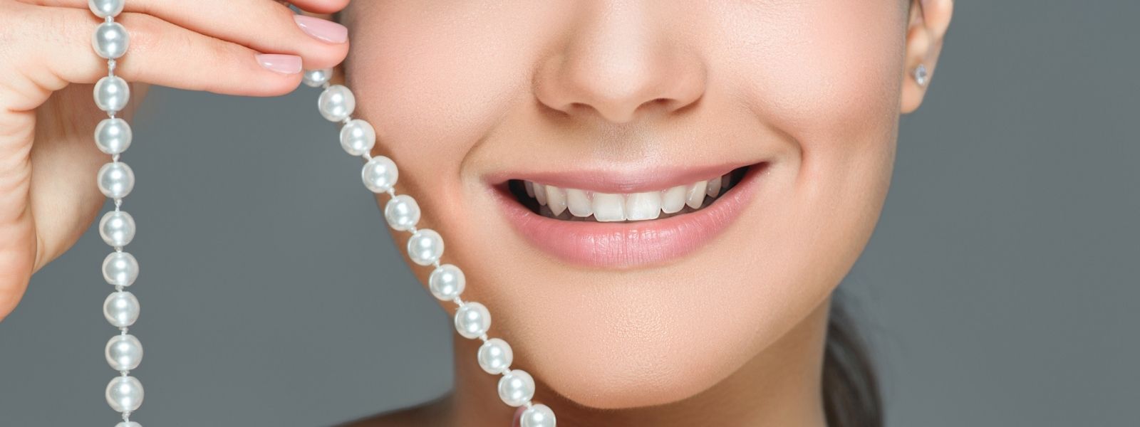 Girl comparing teeth with pearls.